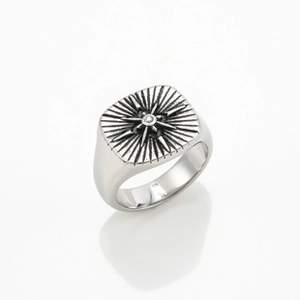 Macro shot of silver Viking compass signet ring with starburst pattern and center stone
