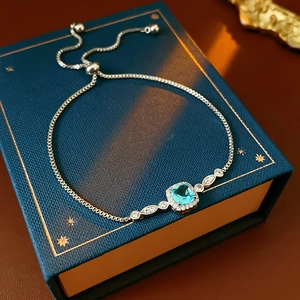 Elegant silver bolo bracelet with blue square zircon and crystals on a starry gift box