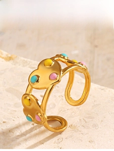 Vue détaillée d'une bague coeur dorée avec des points en émail colorés sur une pierre
