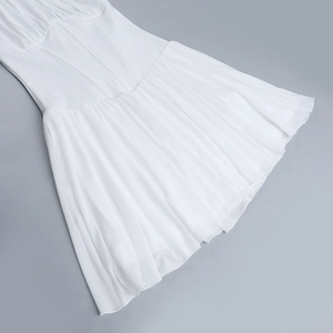 Détail d'une robe dos nu blanche avec tissu plissé léger et textures douces