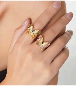 Macro shot of elegant butterfly rings with pink crystals on model's fingers