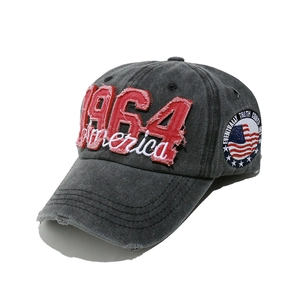Detail of vintage 1964 America embroidery on washed denim baseball cap with side patch