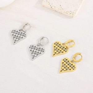 Close-up of gold and silver hollow heart earrings with shimmering rhinestones detail