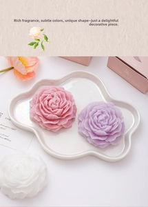 Detailed view of handmade peony shaped candles in pink, purple and white with gift box