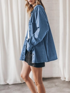 Detail of blue oversized denim shirt featuring vintage loose fit and large front pockets