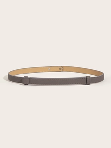 Detail of adjustable gray thin belt with cross grain texture and silver buckles