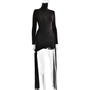 Détail d'une robe noire à col roulé avec jupe froncée et traîne latérale asymétrique