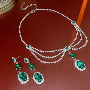 Macro detail of emerald oval earrings and necklace set with sparkling rhinestones