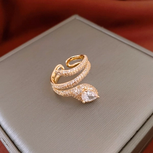 Detailed macro shot of a gold-plated snake ring with a pear-cut diamond on a jewelry box