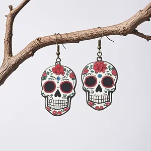 Detail of Day of the Dead sugar skull earrings with floral relief on vintage hooks