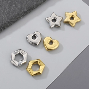 Macro shot of heart, star, and hex stainless steel charms in gold and silver finish