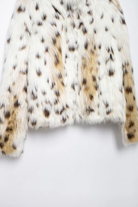 Close-up detail showing soft leopard faux fur texture and pattern on coat sleeve and hem