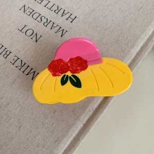 Detail of pink and yellow acetate cowgirl hat hair claw clip with rose floral accents