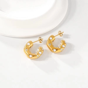 18K gold plated C-shaped earrings with pearls and zircon stones on a white tray