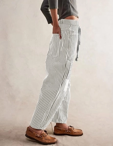 Detailed side view of grey striped wide leg pants featuring drawstring waist and pockets