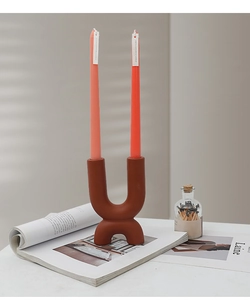 U-shaped ceramic candle holder in terracotta matte finish with two tall scented candles