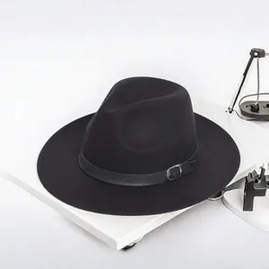 Dettaglio di un cappello fedora nero in feltro a tesa larga con fascia in pelle e fibbia