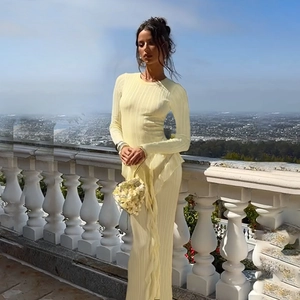 Detail of light yellow ribbed knit dress featuring a slim fit and ruffled hemline