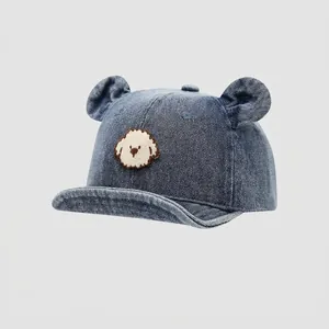 Detail of baby denim cap featuring cute 3D bear ears and a small dog embroidery patch