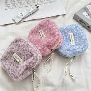 Detailed view of three plush leopard print storage pouches in pink, purple, and blue colors