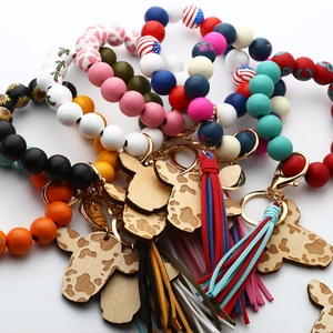 Close-up of Western cow head wooden charms and leather tassels on beaded bracelets