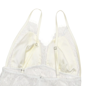 Détail d'une robe en dentelle blanche avec bretelles réglables et broderie florale délicate