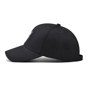 Détail de la broderie papillon rose sur une casquette de baseball en coton noir