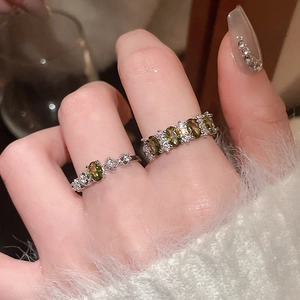 Macro detail of silver vintage rings with olive green stones on a soft background