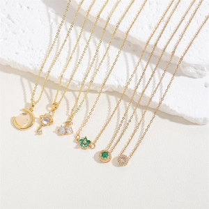Macro detail of gold-plated necklaces with emerald zircon and cherry pendants