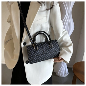 Chic blue polka dot crossbody bag detail with leather handle and gold hardware on a model