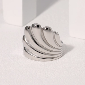 Minimalist silver stainless steel ring featuring a vintage shell relief design on a white surface