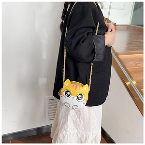 Détail du sac bandoulière chat jaune avec chaîne dorée sur un mannequin enfant