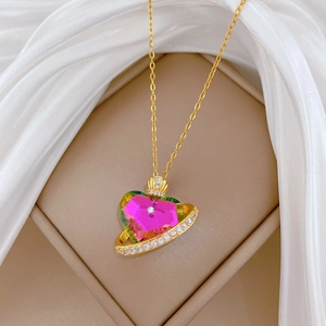 Macro view of gold crown heart pendant with pink crystal and sparkling rhinestones