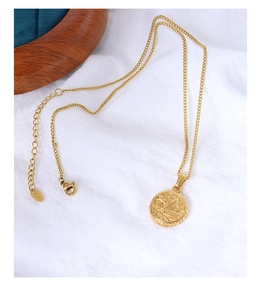 Detailed close-up of 18K gold plated wing pendant with K18 engraved tag and lobster clasp