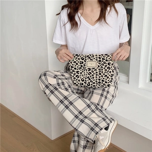 Detail of stylish leopard print canvas pouch with PLEASANT TIME woven label