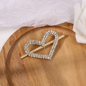 Fashionable heart-shaped alloy hair clip with sparkling rhinestones on a wooden tray