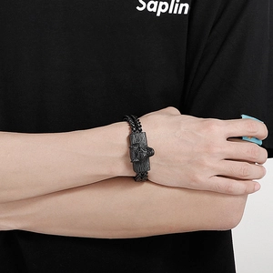 Close-up of men's black titanium steel bracelet with wolf head relief and woven chain
