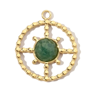 Detailed macro of a gold circular charm with green gemstone and beaded edges