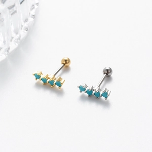 Close-up of gold and silver steel earrings with turquoise stones and screw ball backs