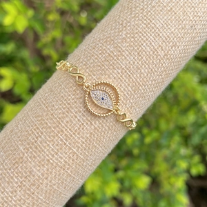 Close-up of 18K gold plated evil eye bracelet with infinity link and zircon stones