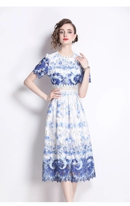 Detail of blue and white lace dress with intricate floral embroidery and scalloped hem