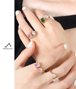 Detail of gold-plated stainless steel open rings featuring pink and green zircon stones