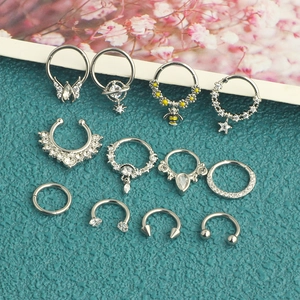 Flat lay of 12-piece silver stainless steel piercing set with zircon bees and daisies