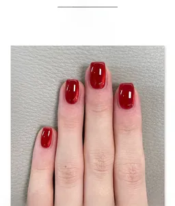 Detail of short square burgundy wine cat eye fake nails with glitter glossy finish
