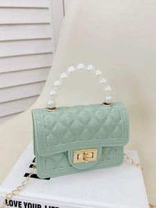 Mint green mini crossbody bag with pearl handle and quilted texture on book