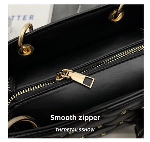 Close-up of smooth gold metal zipper and quilted leather on black shoulder bag