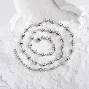 Minimalist silver heart link necklace in stainless steel on white stone background