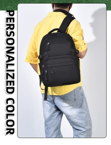 Detail view of durable black multi-pocket backpack worn by a model in a yellow shirt