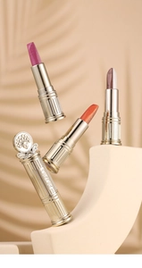 Detailed macro view of dual-color eyeshadow sticks with vintage gold embossed tubes
