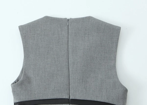 Close-up of invisible zipper and seam detail on a grey satin bow mini dress